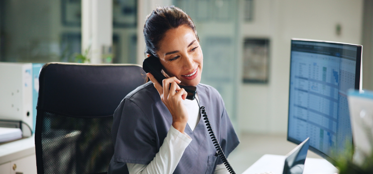 medical administrative assistant answers a phone call in a medical office